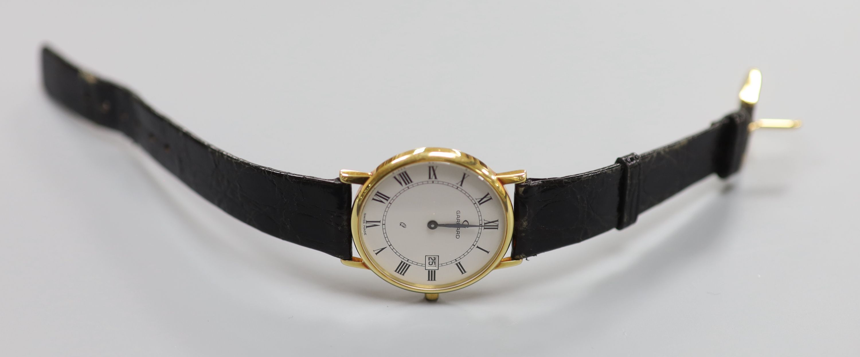 A gentlemans modern 18ct gold quartz dress wrist watch, retailed by Garrard, on a black leather strap, with Garrard box,